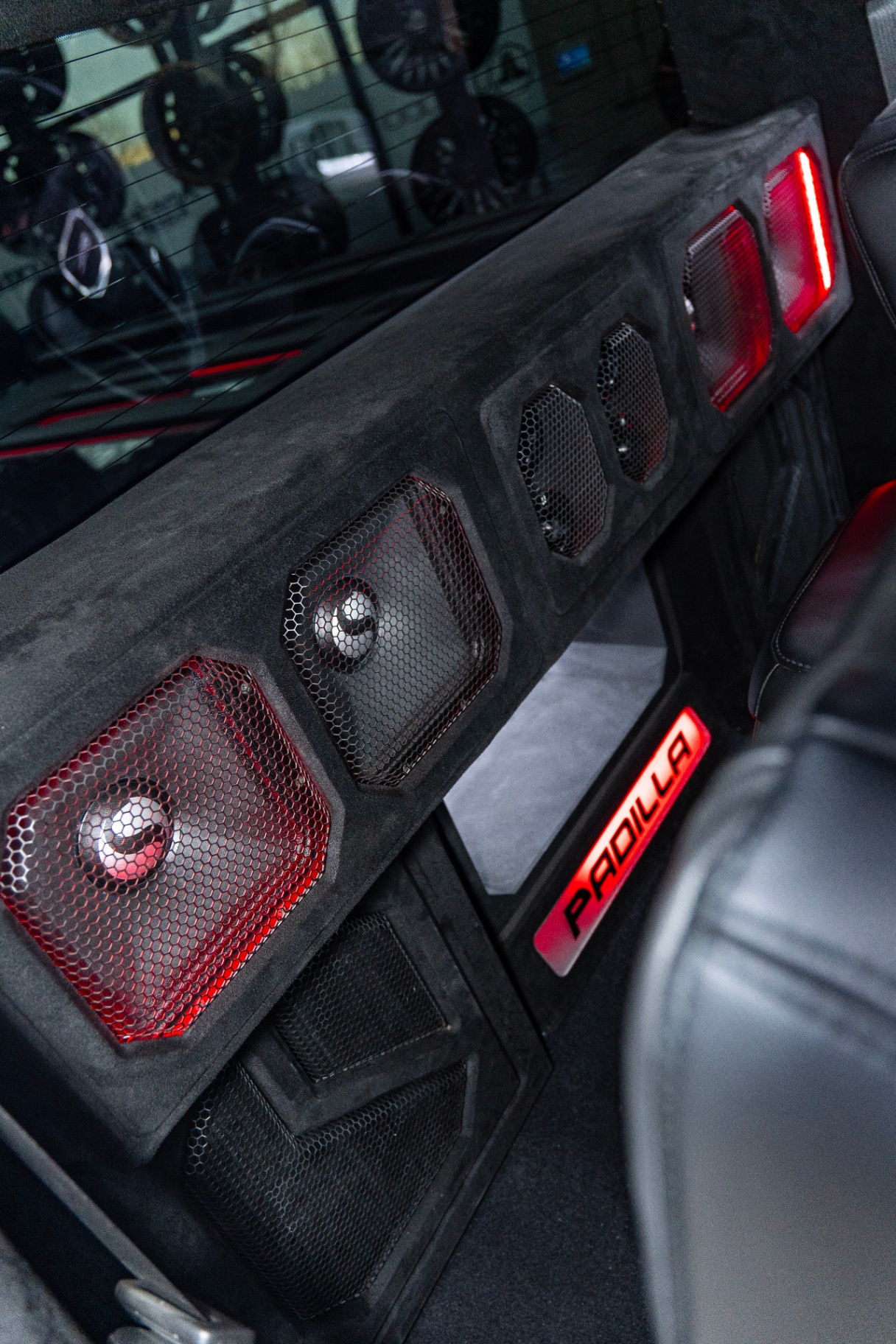 Rear cab Kicker speaker enclosure with red LEDs and Padilla custom plate in GMC Sierra