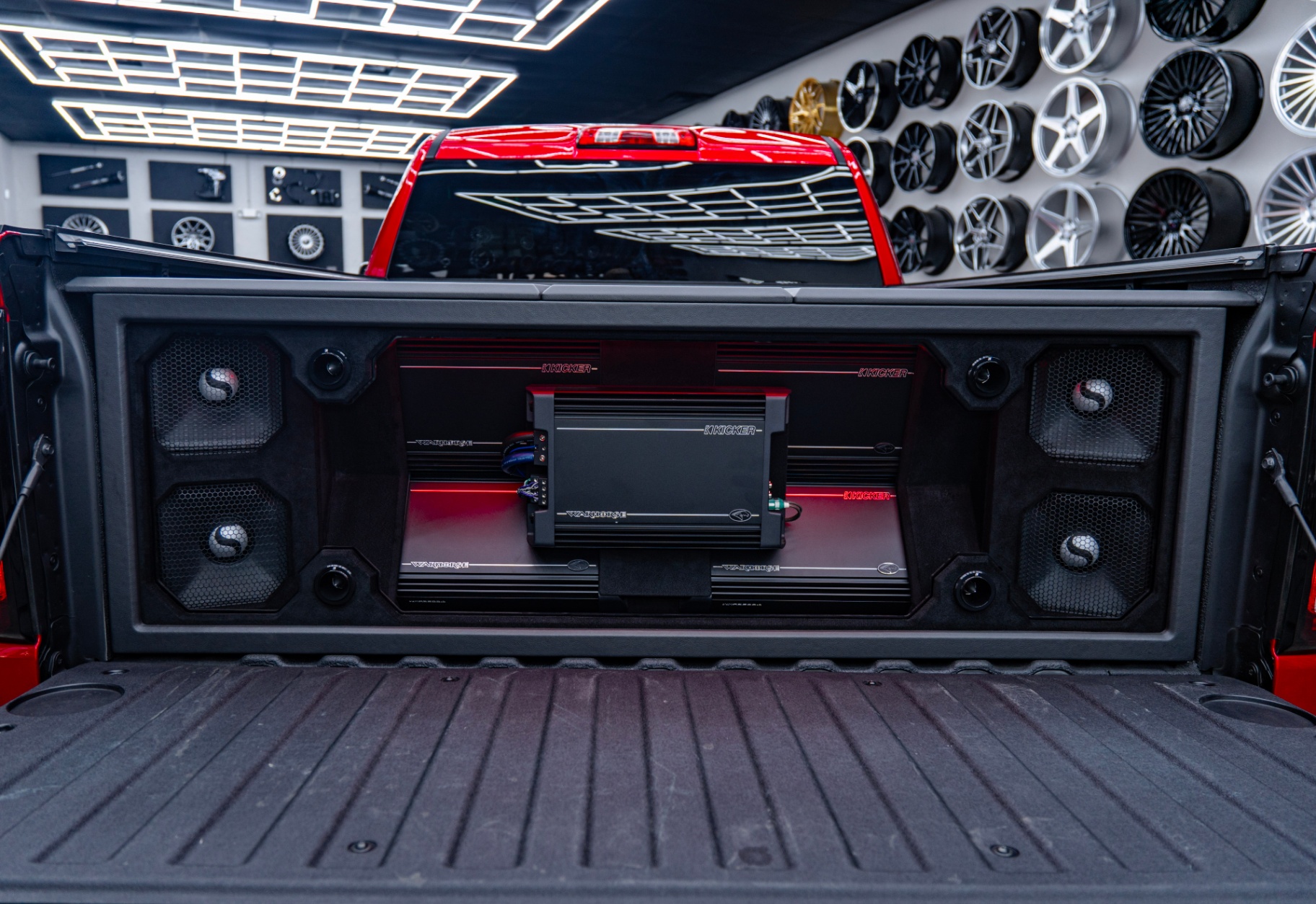 GMC Sierra bed with Warhorse amplifiers and Kicker subwoofer wall under the tonneau