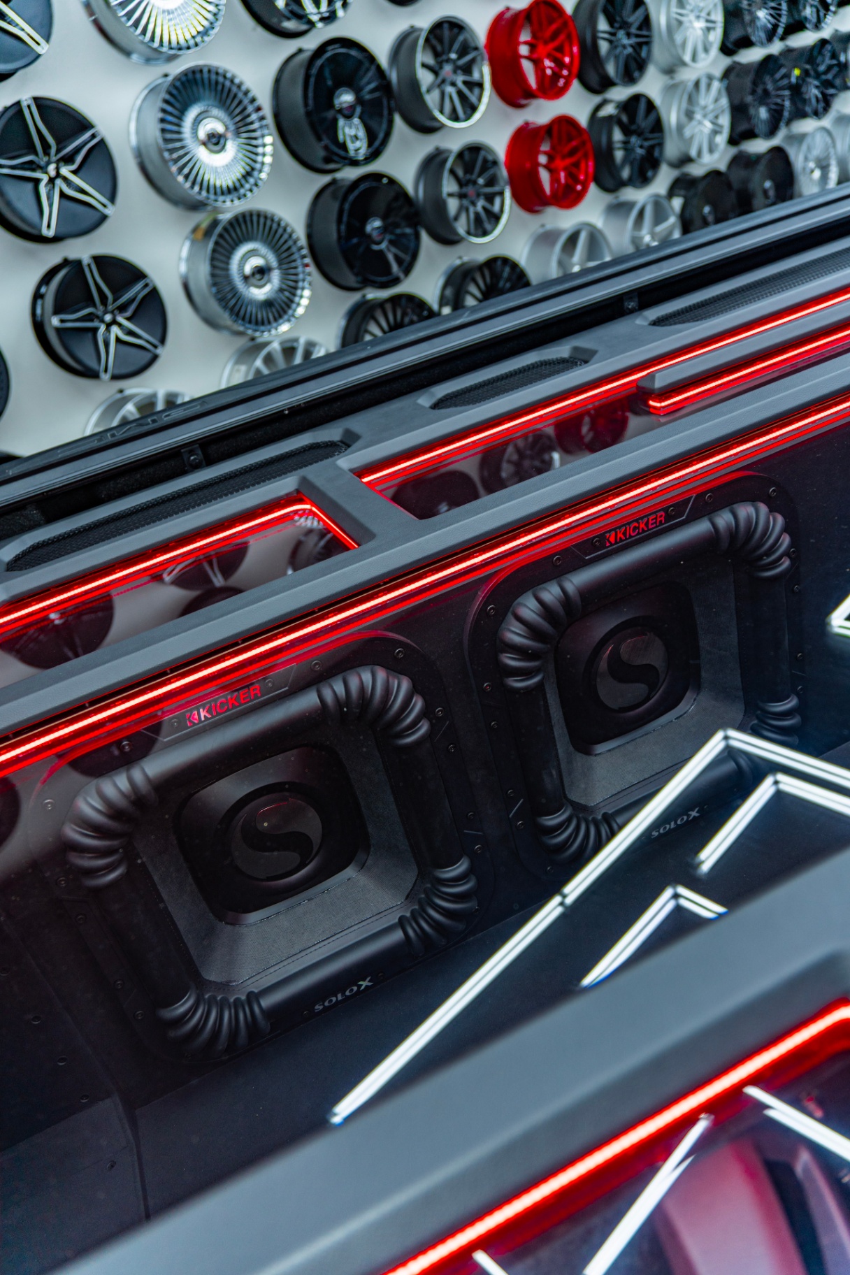 Overhead view of GMC bed audio install with backlit acrylic panels and Kicker subs