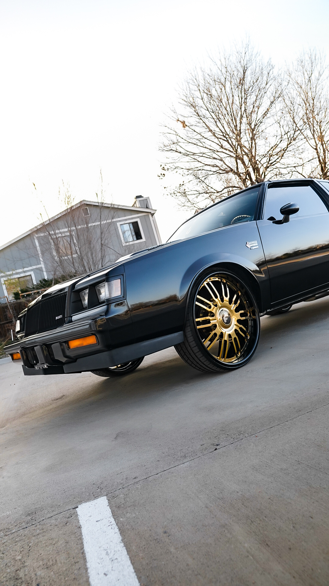 Low-angle front three-quarter of Buick Grand National on gold Forgiato wheels